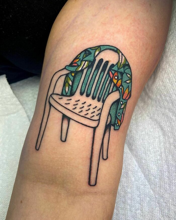 Memorial tattoo of a white chair with a colorful patterned blanket draped over it.