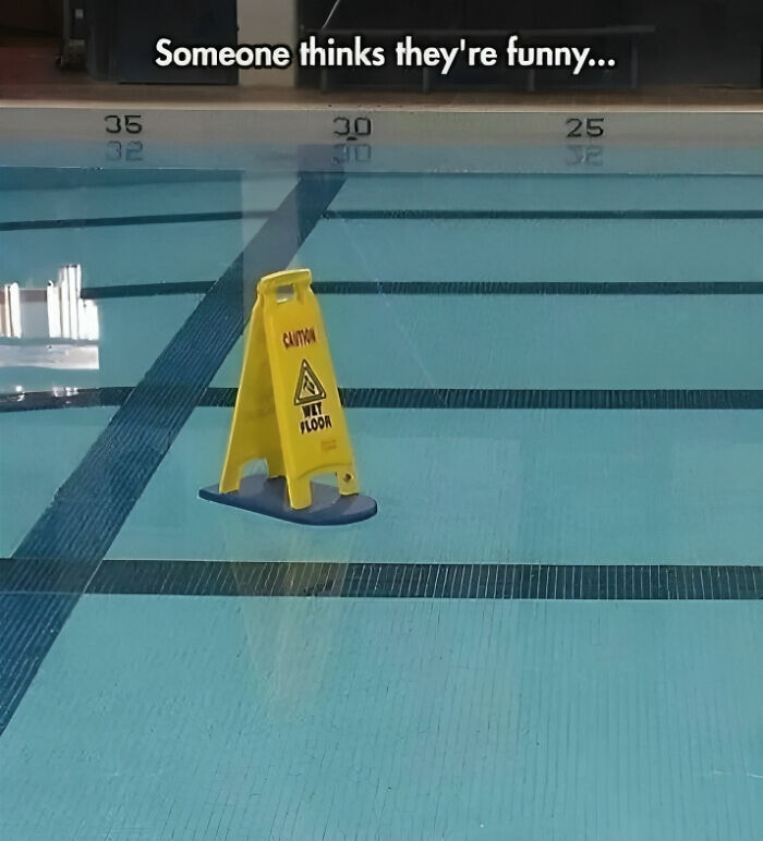 Wet floor sign floating in a swimming pool, showcasing funny meme humor for pun enthusiasts.
