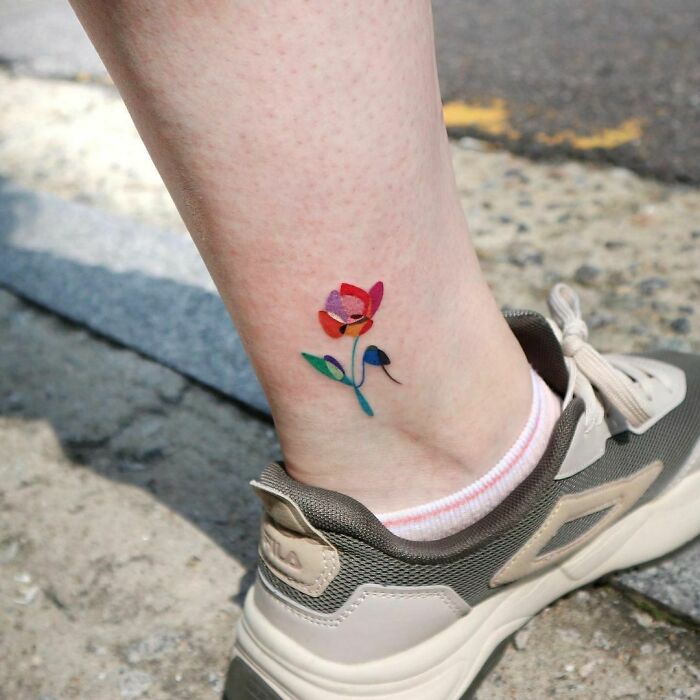 Colorful flower ankle tattoo with sneaker, showcasing tattoo care inspirations.