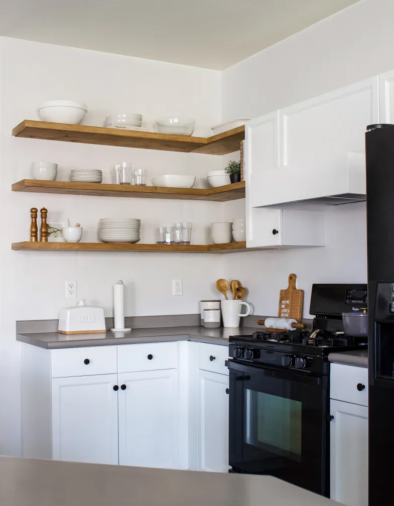 White kitchen with three wooden floating corner shelves