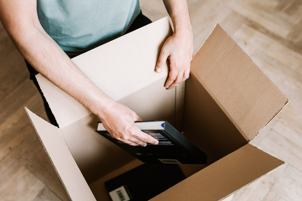 Man putting books in a carton box