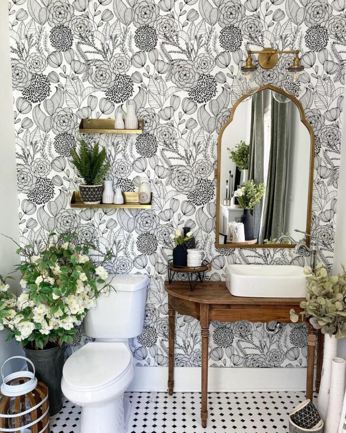 Bathroom with black and white bold floral wallpaper featuring a wooden sink table and white toilet for trendy bathroom wallpaper ideas.