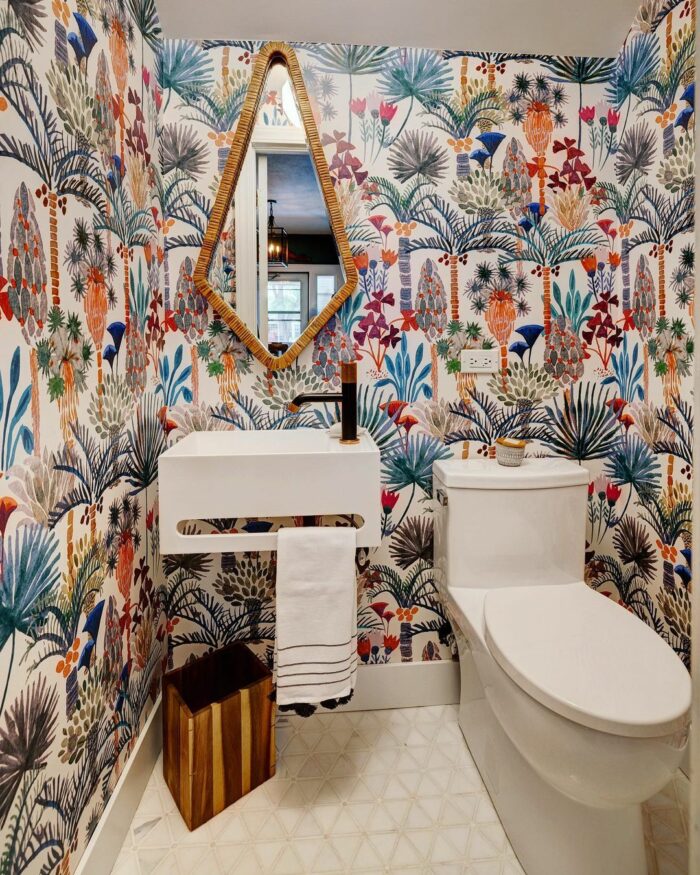 Bathroom with colorful floral wallpaper, modern sink, and toilet showcasing trendy bathroom wallpaper ideas.