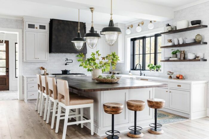 White kitchen with marble table wooden chairs and lights White kitchen with marble table wooden chairs and lights