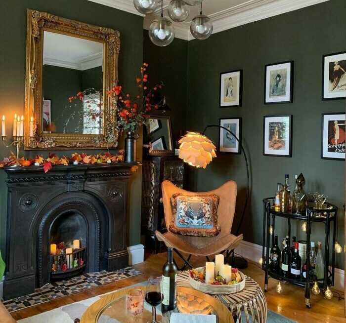 a maximalist living room with green walls, a fireplace, and a unique chandelier a maximalist living room with green walls, a fireplace, and a unique chandelier