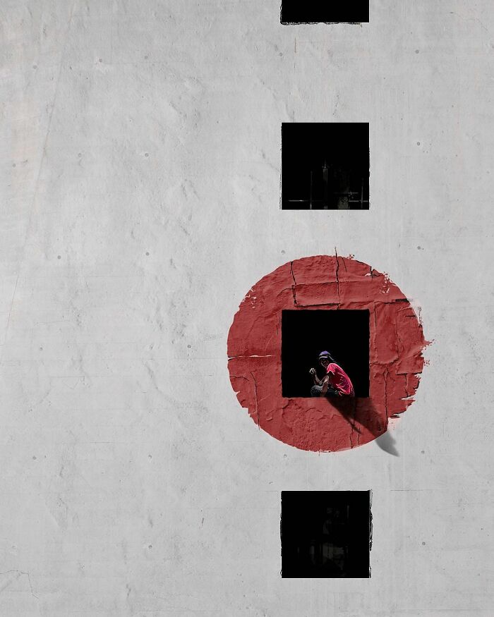 A photograph of a person looking out the window