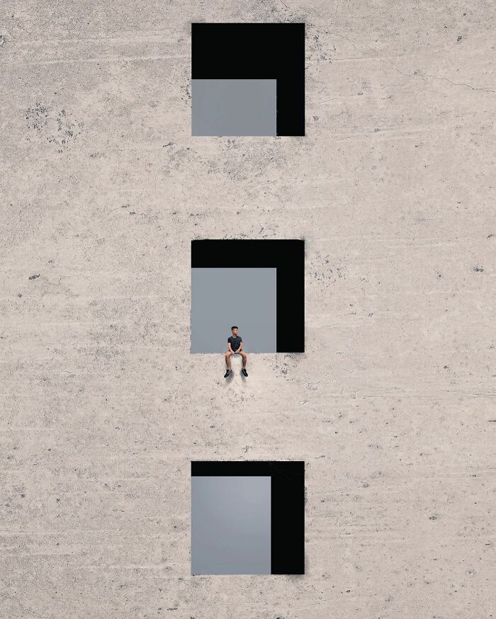 A photograph of a man sitting on a building