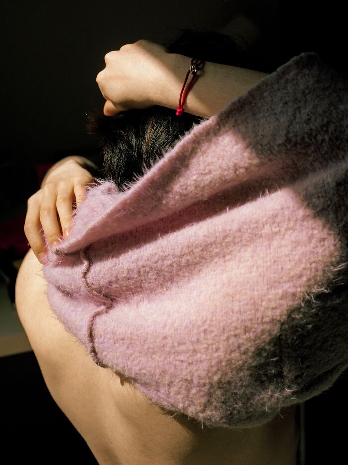 A picture of a person taking off their shirt