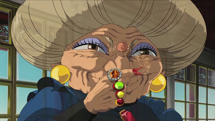 Elderly anime character with large earrings and colorful rings, in a room with window panes, symbolizing themes of love and loss.
