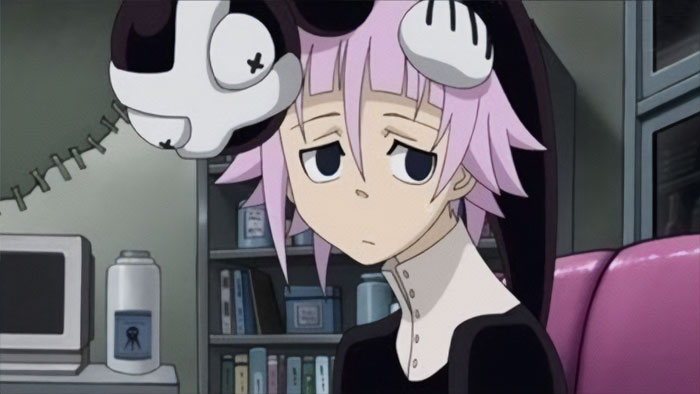 Anime character wearing a black and white hat, sitting in a library, looking sad.