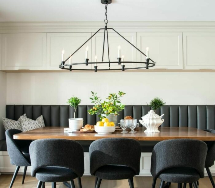 Black banquette seating with wooden table and black chairs in a modern dining area showcasing banquette seating ideas.