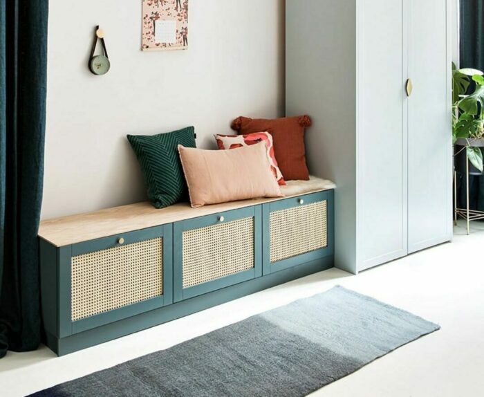 Green banquette seating with colorful pillows in a cozy corner, showcasing stylish banquette seating ideas.