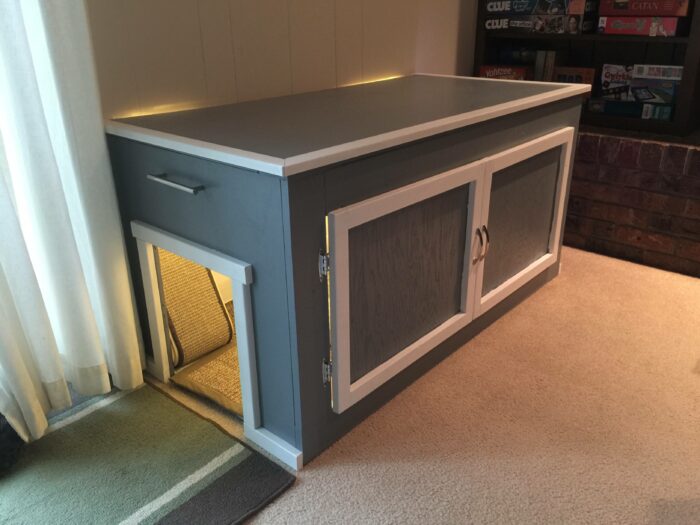 Gray cat litter box banquette with sleek storage doors, fitting seamlessly into cozy living space banquette seating ideas.