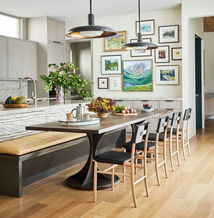Wooden brown banquette seating paired with a sleek wooden table and modern chairs in a bright, stylish kitchen.