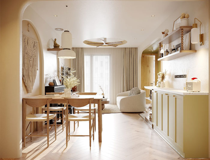Boho decor dining space with wooden table and green kitchen cabinets creating a chic and cozy atmosphere.