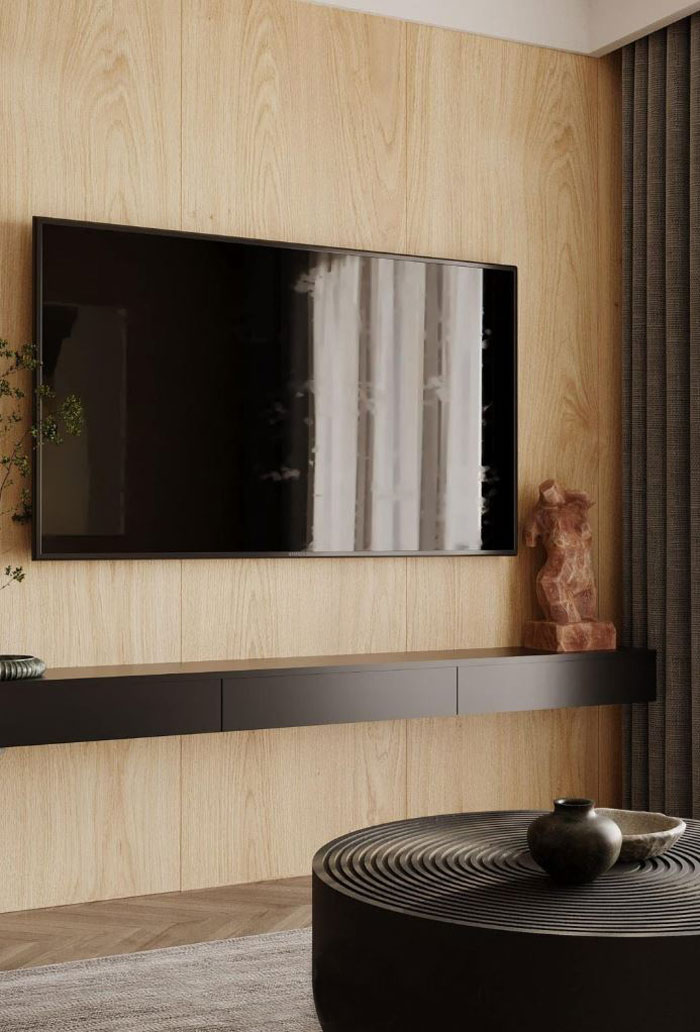 Wall-mounted TV above a dark brown shelf featuring a statue and plant, reflecting unique boho decor ideas for a chic space.