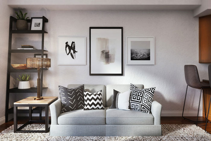 Light gray two-person couch with black and white patterned throw pillows in a modern living room setup. Light gray two-person couch with black and white patterned throw pillows in a modern living room setup.