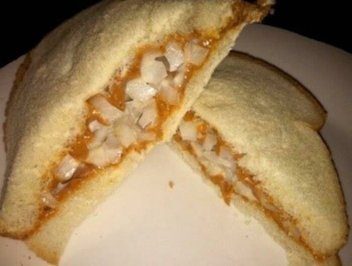 Cursed food close-up: peanut butter and onion sandwich on white bread.