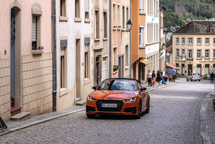 Orange car parked on cobblestone street in Vianden showcasing culture facts reflecting world diversity and beauty