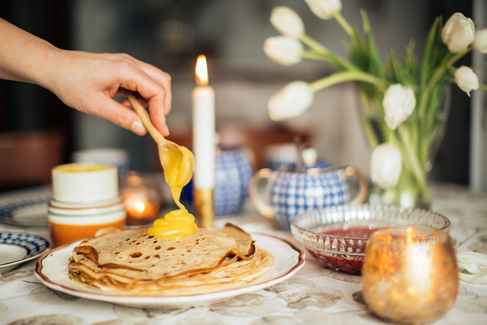 Person spreading custard on crepe, showcasing food culture as part of diverse culture facts around the world.