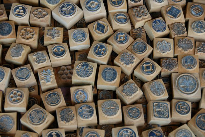 Many small blue hanko stamps showcasing cultural diversity and traditional craftsmanship from around the world.