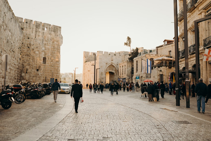 People walking on a cobblestone street in Jerusalem, Israel, showcasing culture facts and the diversity of the world.