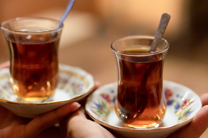 Two Turkish cups of tea on floral plates showcasing culture facts reflecting diversity and beauty of the world.