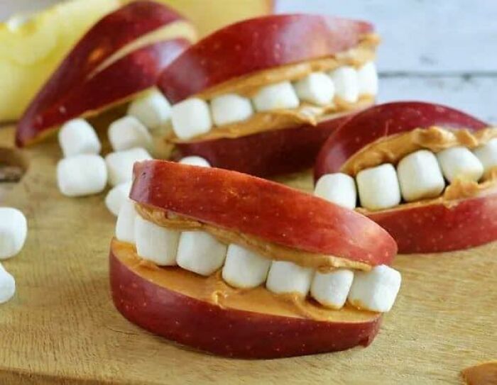 Cursed foods: apple slices with marshmallows and peanut butter, resembling teeth.