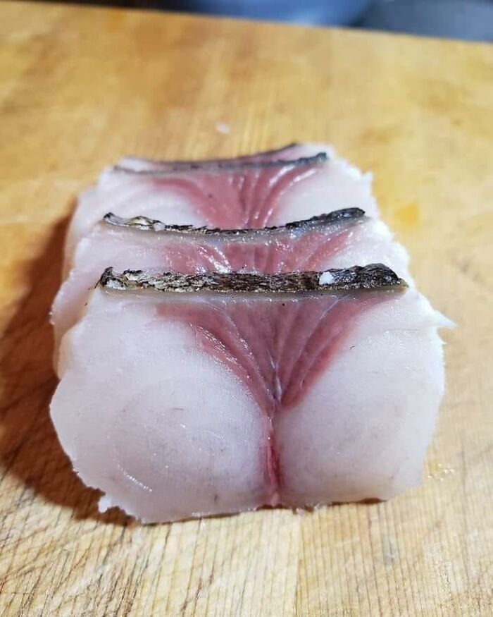 Cursed food resembling fish fillet with unusual shapes on a wooden board.
