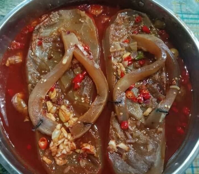 Cursed foods: two cooked flip-flops in a spicy sauce with chopped garlic and chilies.
