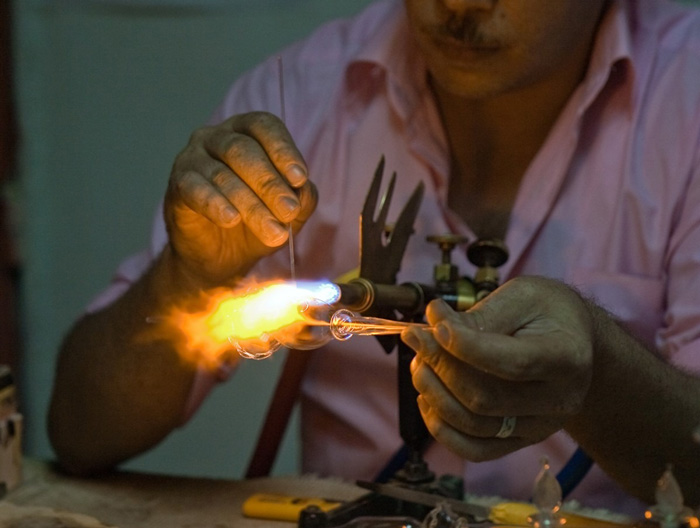 Man making glass bottles