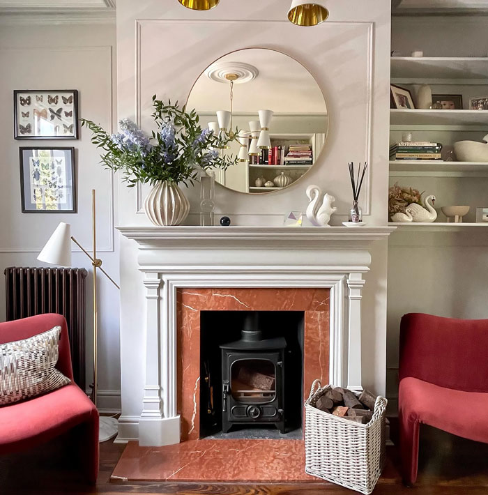 Bright living room featuring a red marble fireplace with a white detailed fireplace mantel and cozy seating.