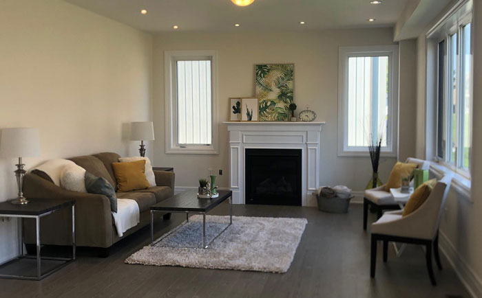 Simple white fireplace mantel with stacked artwork above, creating a clean and elegant hearth design in a modern living room.