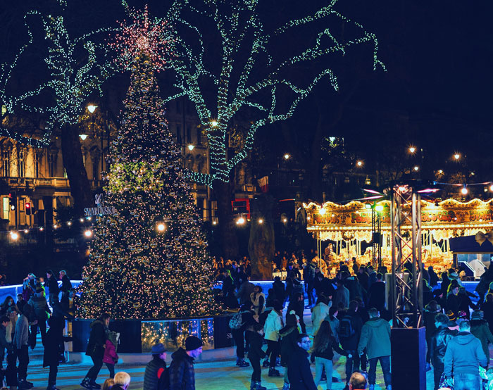 Christmas tree in London surrounded by people 
