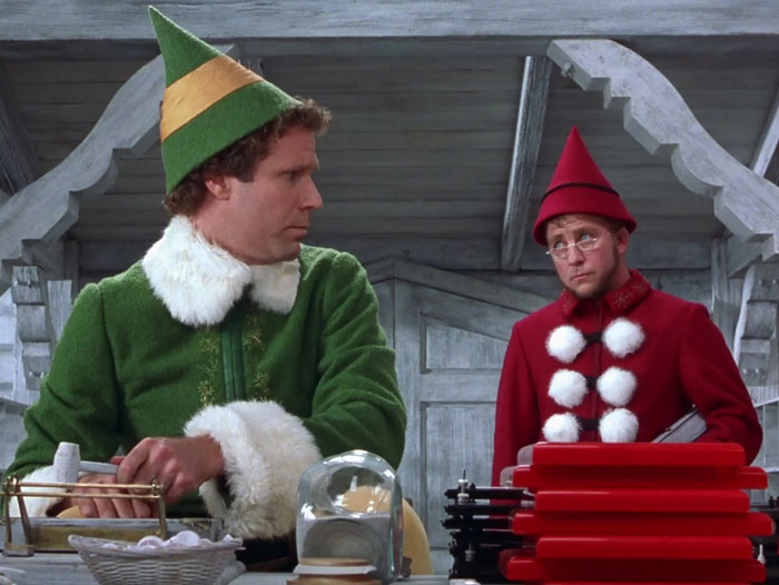 Buddy and another elf packing gifts 