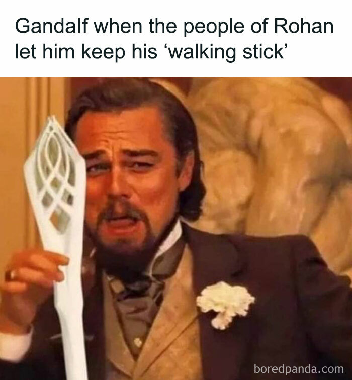 Actor holding a staff with a humorous expression, referencing Middle Earth.