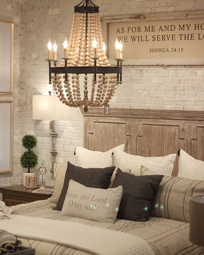 Cozy master bedroom with whitewashed brick wall, wooden headboard, and layered pillows showcasing master bedroom ideas.