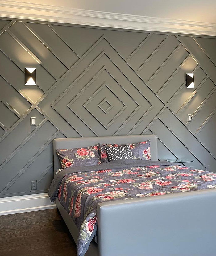Master bedroom ideas featuring a modern gray accent wall with geometric design and floral bedding in a bright bedroom setting