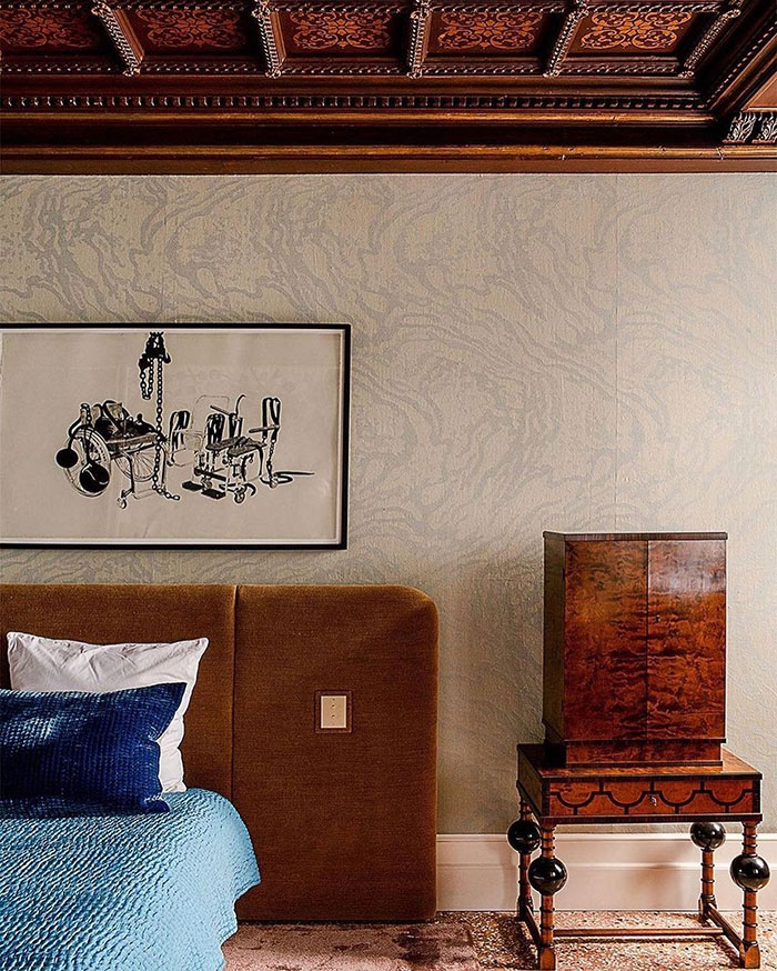 Antique table standing near a bed in a master bedroom showcasing classic master bedroom ideas and design elements.