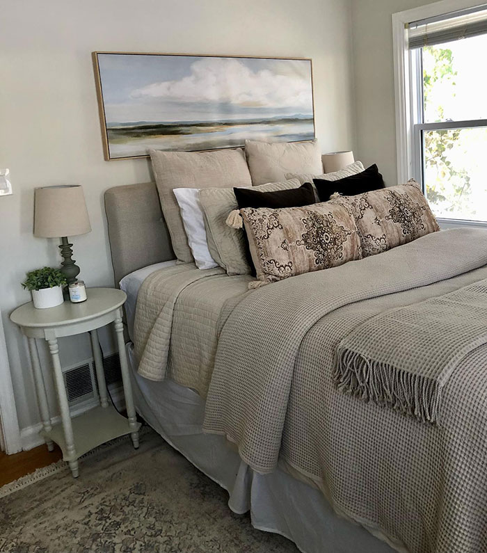 Cozy grey bed with layered pillows and textured blankets creating a peaceful master bedroom design idea.