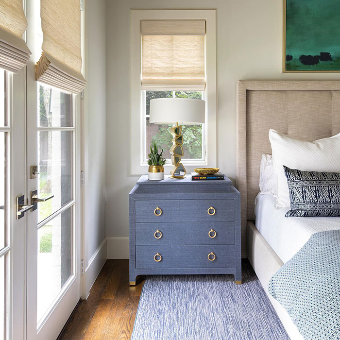 Blue nightstand with gold accents next to bed in a master bedroom showcasing stylish master bedroom ideas and design.