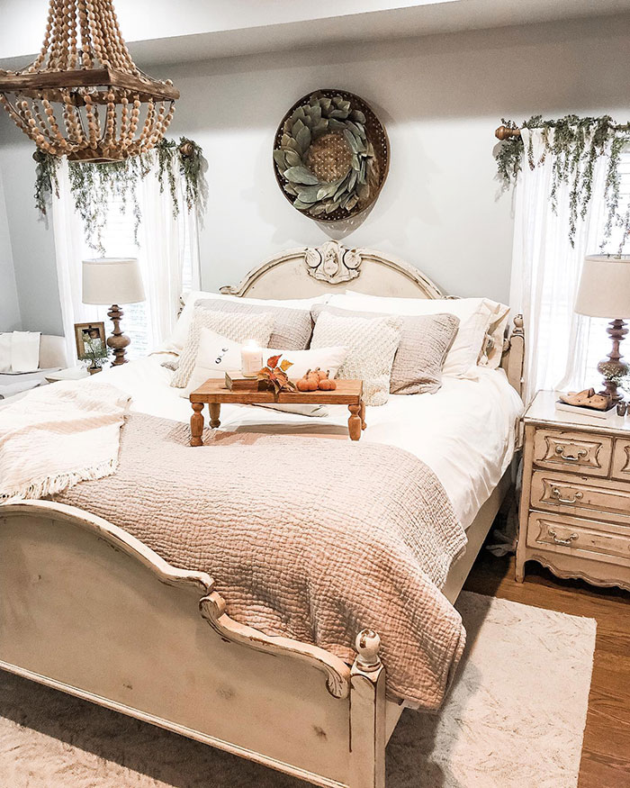 Retro rustic white master bedroom with cozy quilt, vintage furniture, soft lighting, and farmhouse-inspired decorative accents.