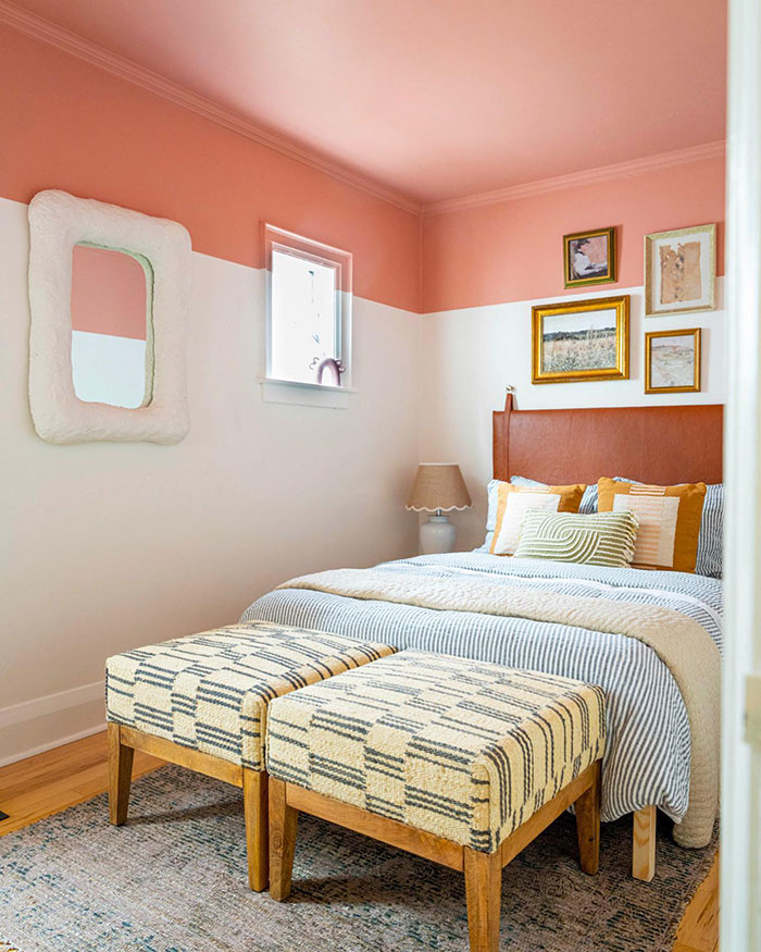 Cozy colorful master bedroom ideas featuring patterned stools, warm pillows, and dual-tone pink and white walls.