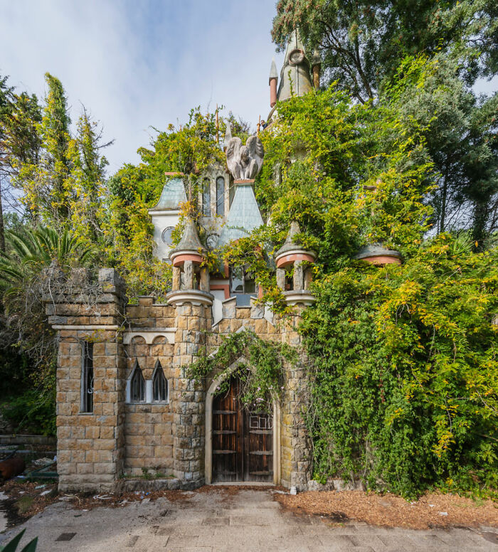 Overgrown abandoned castle entrance surrounded by dense vegetation in a post-apocalyptic world setting.