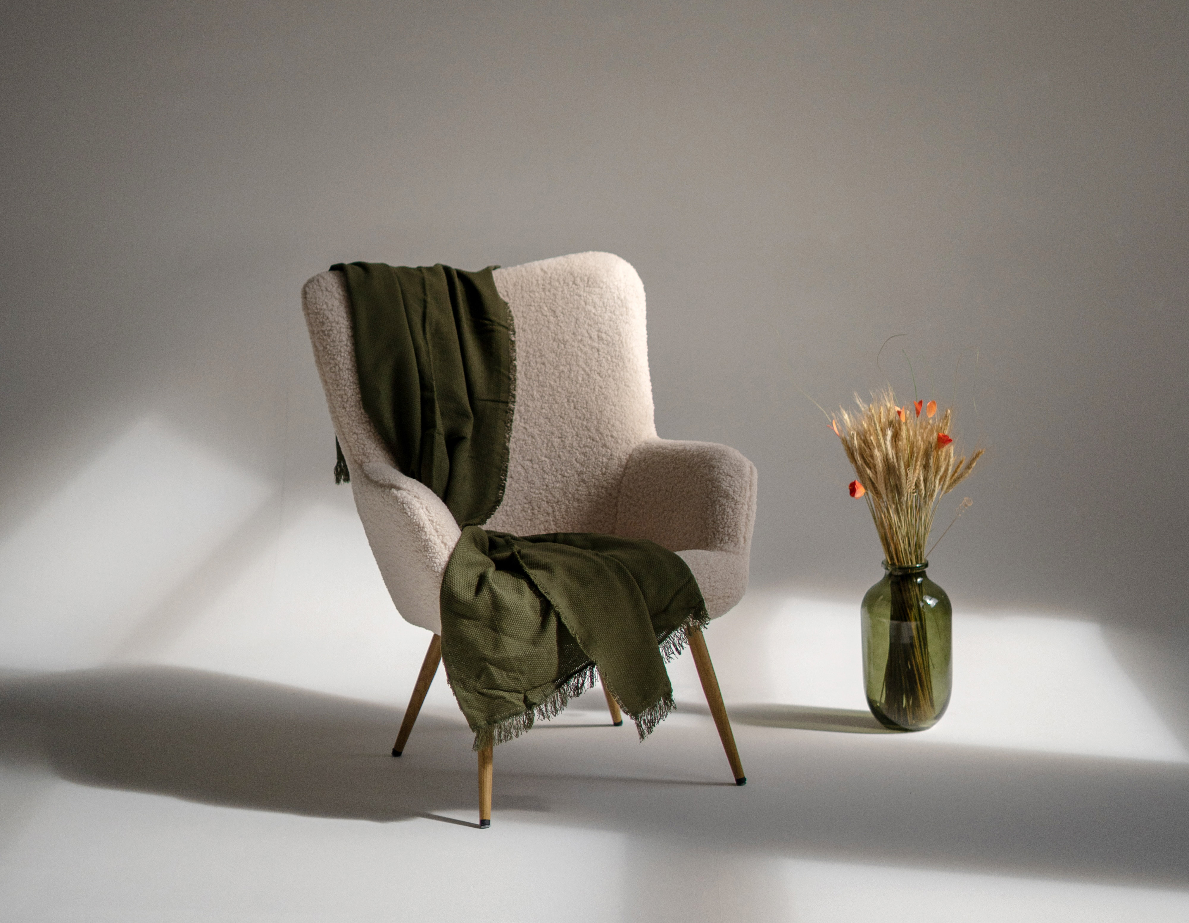 a chair and a vase with flowers in it