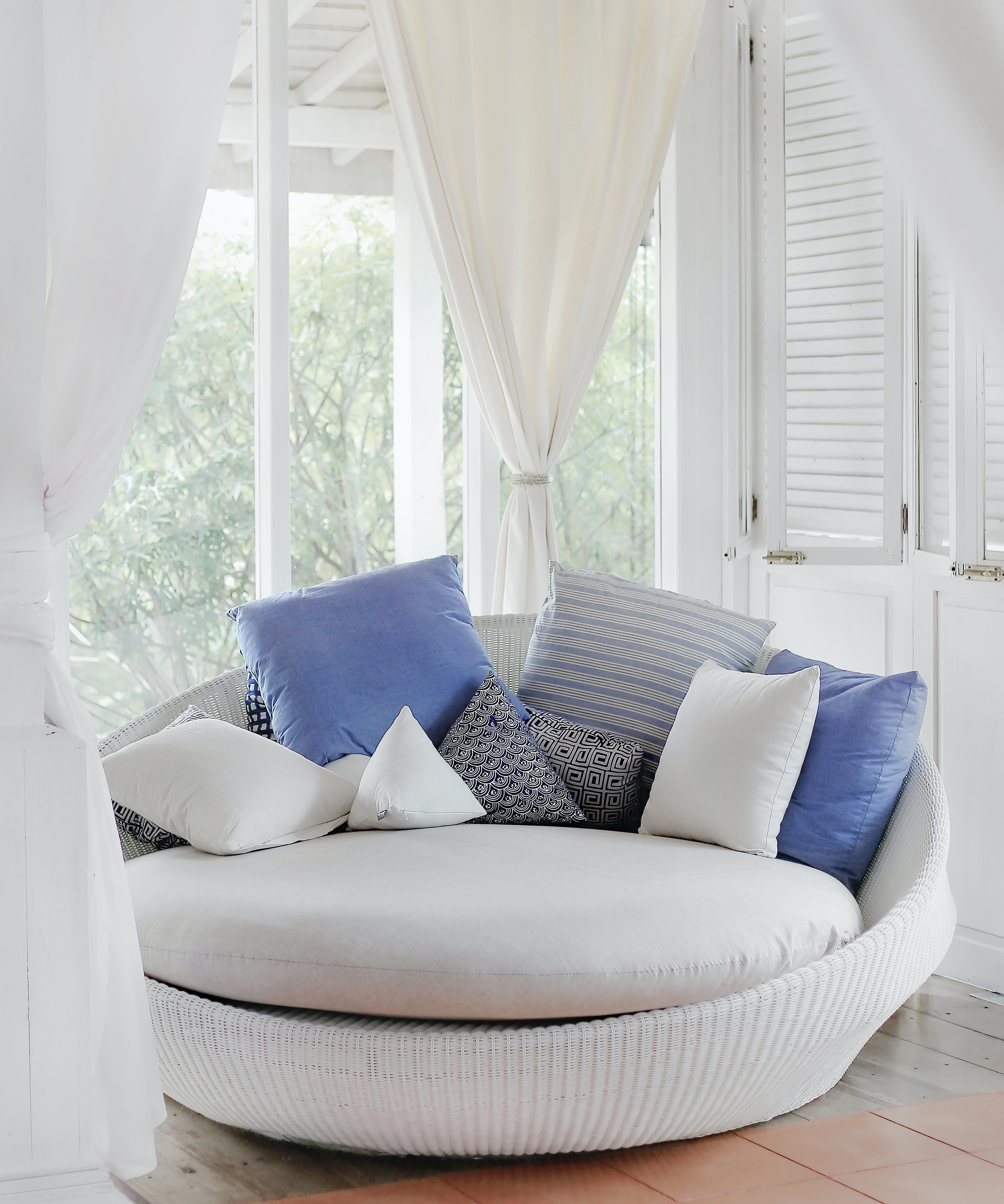 white cuddle chair and throw pillows near window