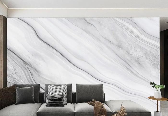 Living room with stylish removable mural wallpaper featuring a marble design behind a gray sectional sofa.