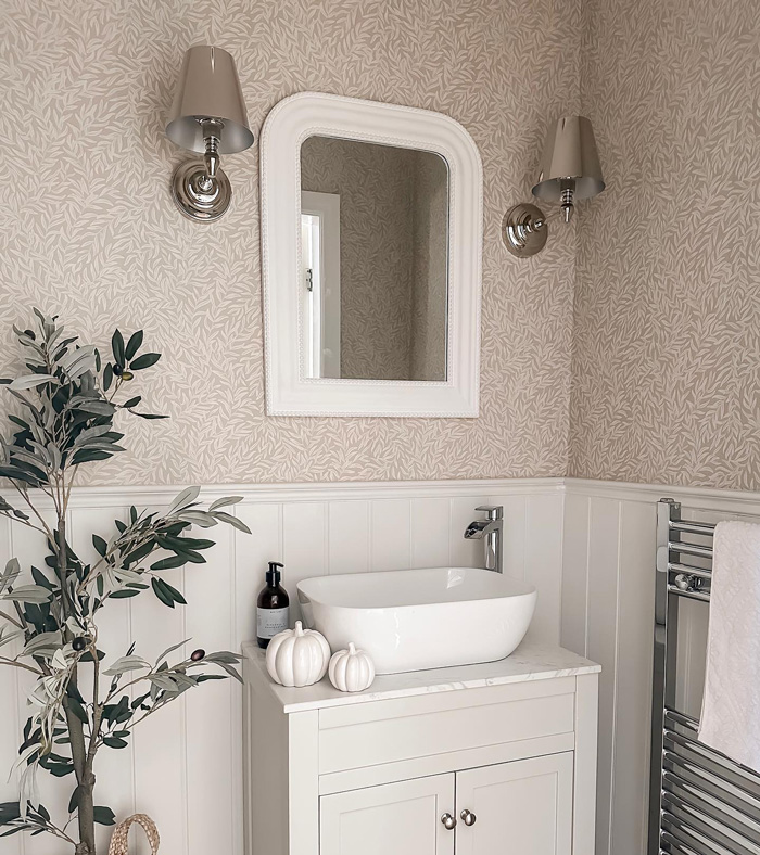 Bathroom featuring stylish removable wallpaper with a white framed mirror and modern sink for decor ideas.
