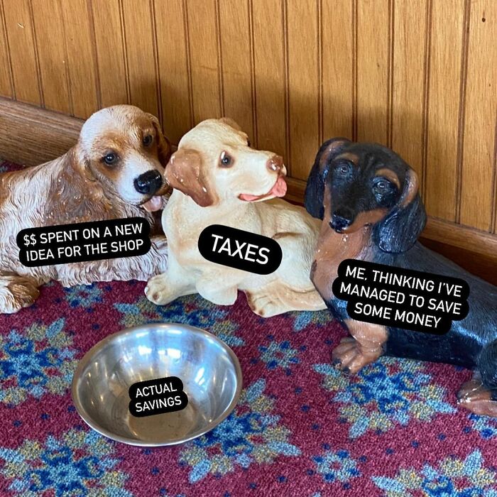 Three dog statues labeled with small biz troubles, humorously depicting spending, taxes, and savings.