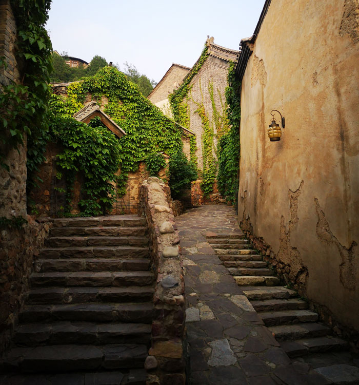 gray concrete stairs between brown concrete houses during daytime in China